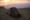 tent pitched on barren escarpment at sunset