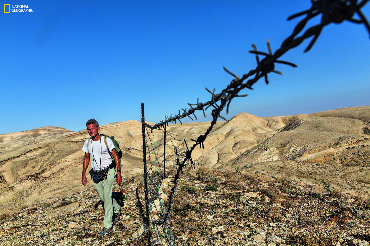 Striding toward Bethlehem, in the West Bank, Salopek is detoured by a herder’s tattered fence, one of the first human-made barriers—other than checkpoints and border gates—he’s faced in some 2,300 miles since he started out in Ethiopia. Join the journey at outofedenwalk.org.Photograph by John Stanmeyer / National Geographic