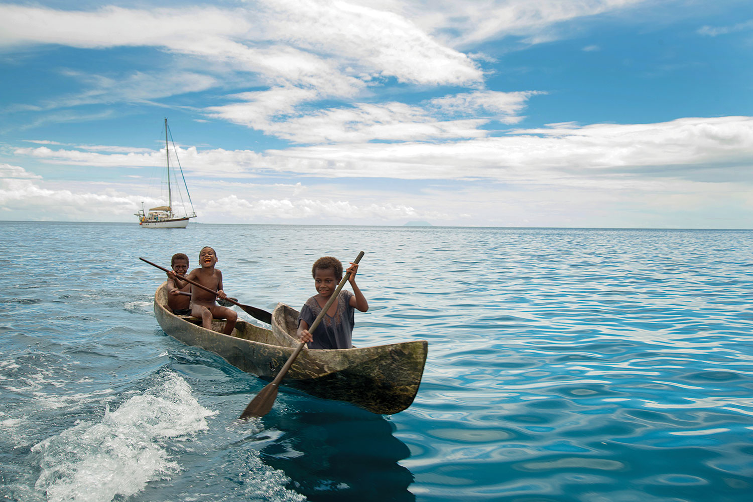 W From dawn to dusk, curious kids from neighboring villages would paddle around Anna Rose while we were at anchor, laughing, gawking, and playing in the water.