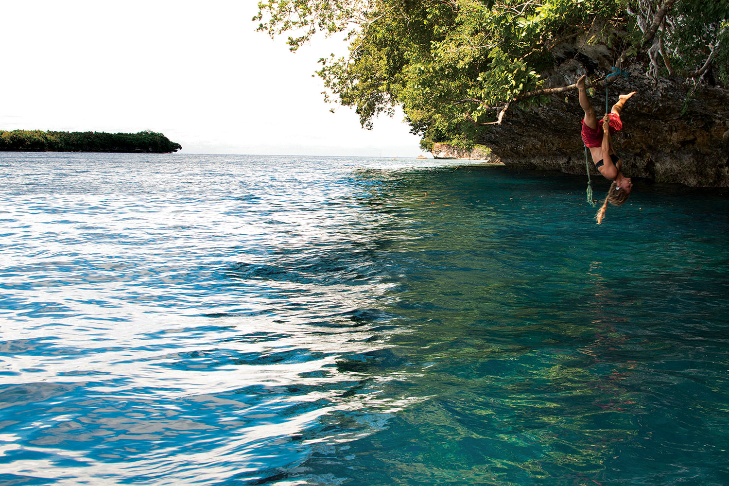 With a huge smile and belly laughs, Charlotte shows her acrobatic prowess on a rope swing hung by children from a nearby village. The turquoise water below hides an extraordinary reef wall for snorkeling and diving, while manta rays frequently migrate through the deep channel beyond.