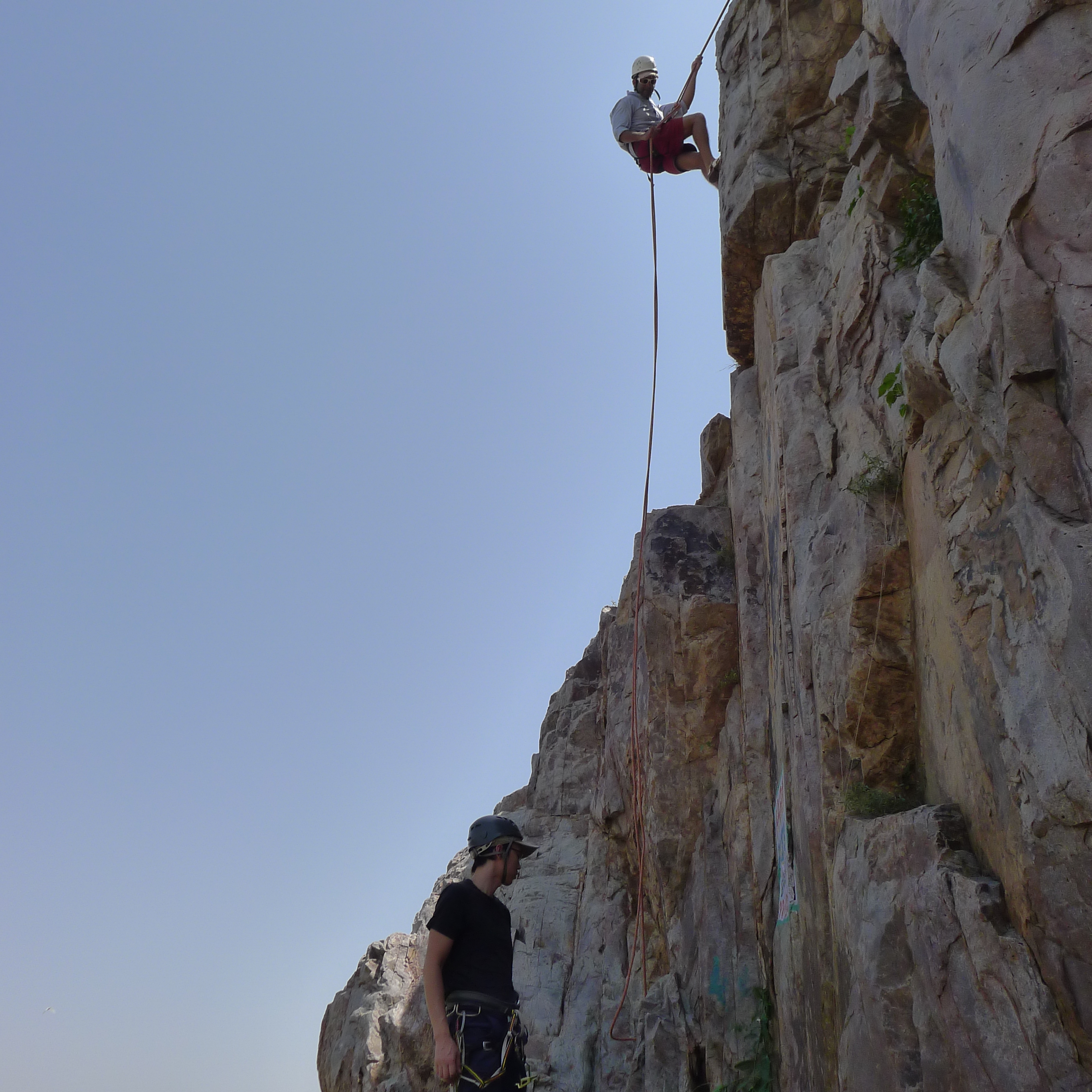 Abseiling down the rock face in the Harminder area after having fixed the anchors at the top. 