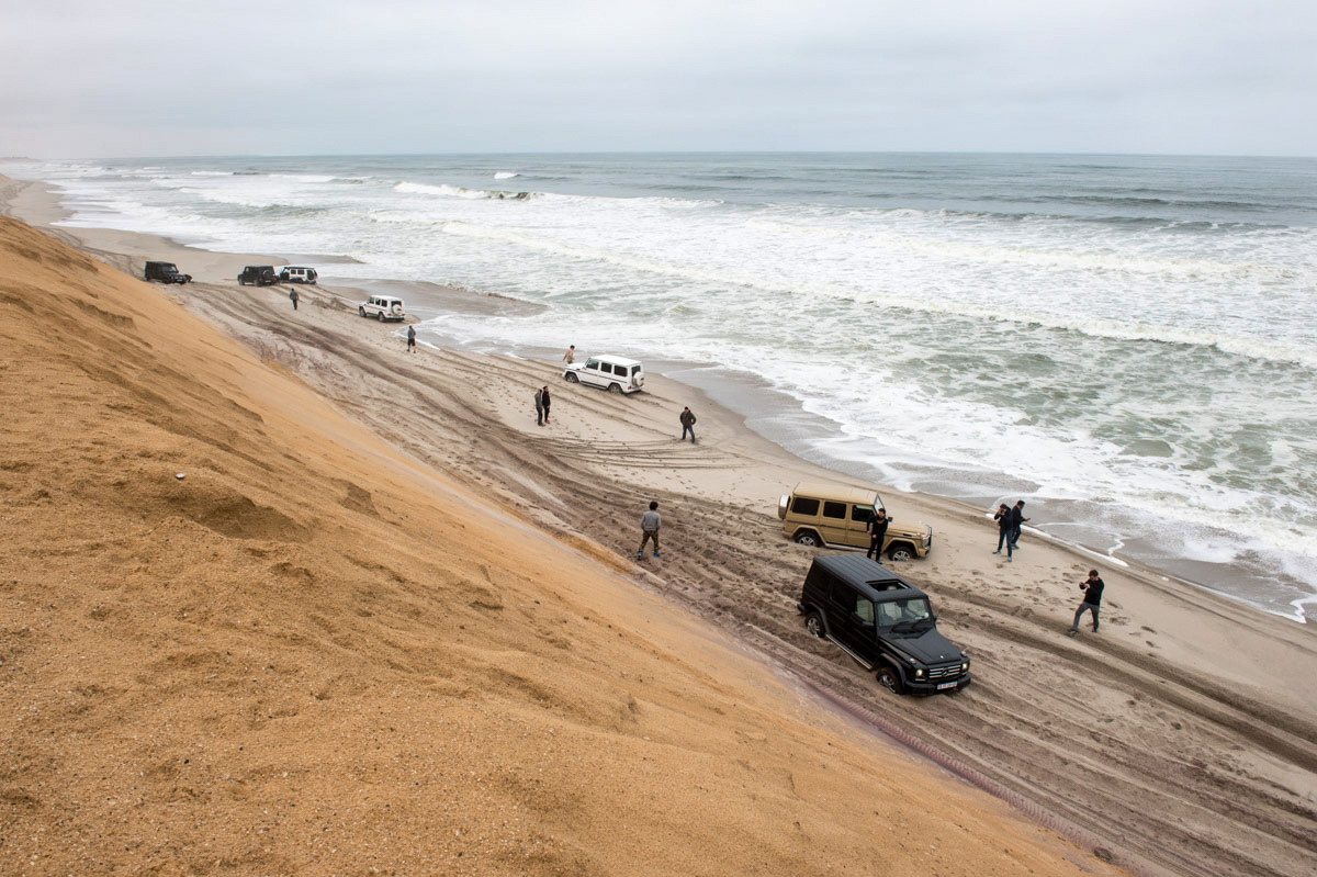 Six Mercedes Benz G-class SUVs find themselves trapped in deep sand, with the tide coming in on one side, and steep sand dunes on the other. We probably have less than 30 minutes to dig out all vehicles and get them turned around and up through a passage in the dunes. Photo: Dmitry Sharomov
