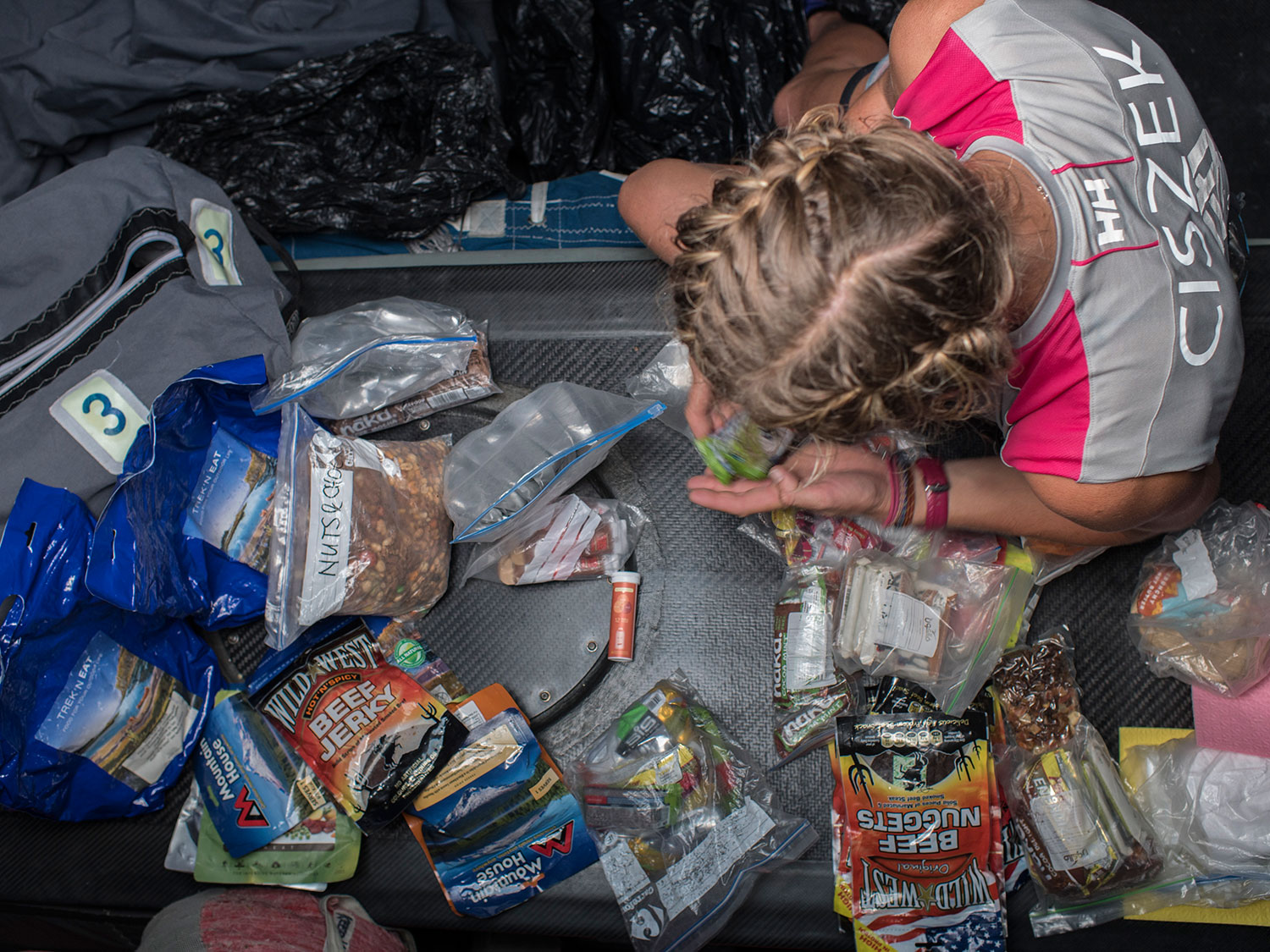 Sophie Ciszek organizes and consolidates a few food bags. The boat carries only freeze dried or similar expedition food. Cooking on board a racing yacht that's constantly moving is no easy task. PHOTO: CORINNA HALLORAN / TEAM SCA / VOLVO OCEAN RACE